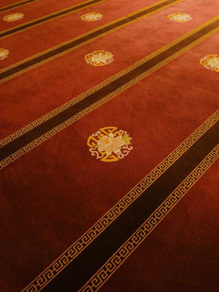 Rich ornamental carpet with intricate patterns in warm tones, perfect for luxurious interiors.
